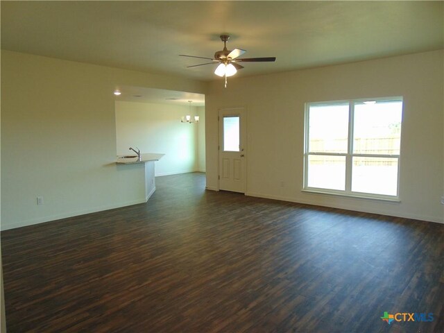 3204 Salt Fork Dr, Killeen, TX 76549 - unfurnished living room featuring ceiling fan, dark wood-style flooring, a chandelier, baseboards, and a sink