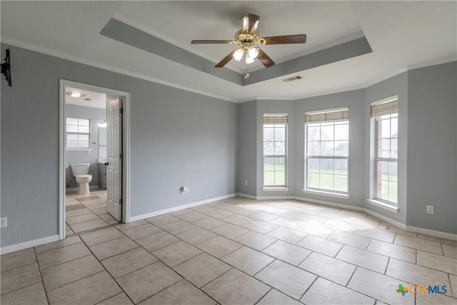 unfurnished room featuring a tray ceiling, a wealth of natural light, ornamental molding, and ceiling fan