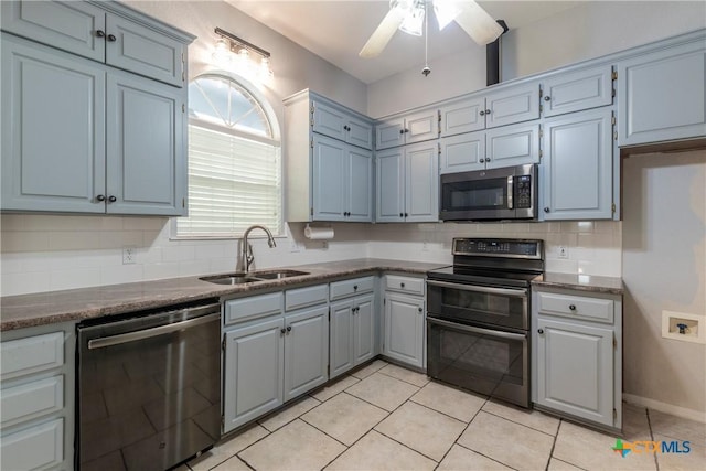 kitchen featuring backsplash, stainless steel appliances, ceiling fan, sink, and light tile patterned floors