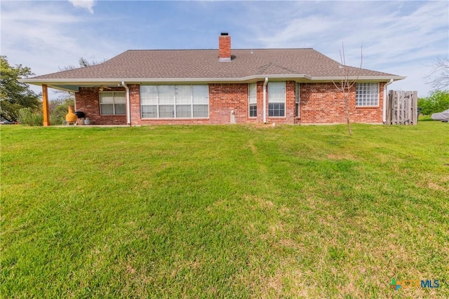 rear view of property with a lawn