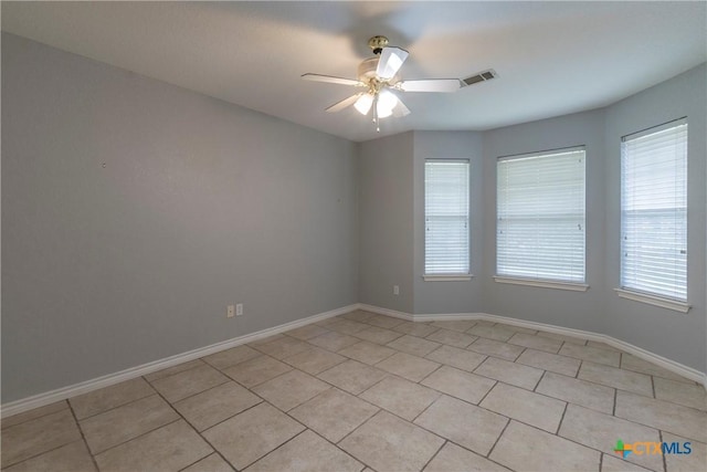 tiled empty room featuring ceiling fan