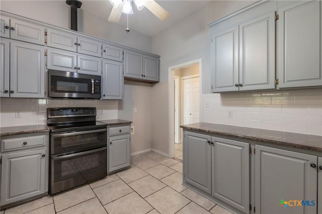 kitchen with gray cabinetry, ceiling fan, light tile patterned floors, appliances with stainless steel finishes, and tasteful backsplash