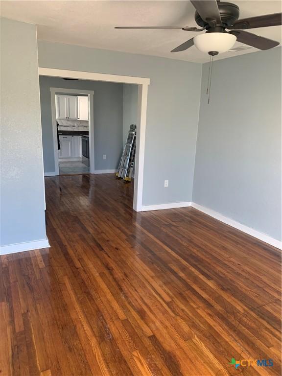 spare room with dark hardwood / wood-style floors and ceiling fan