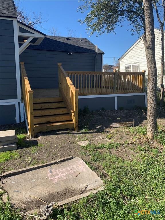 rear view of property featuring a wooden deck