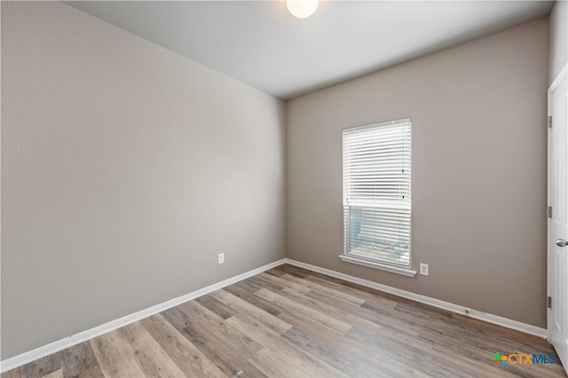 spare room with light wood-style flooring and baseboards