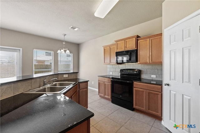 kitchen with dark countertops, a sink, backsplash, and black appliances