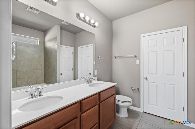 bathroom featuring tile patterned flooring, visible vents, a sink, and double vanity