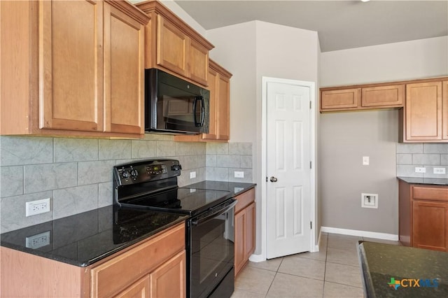 kitchen with backsplash, light tile patterned flooring, black appliances, dark stone counters, and baseboards