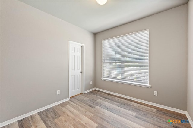 unfurnished room with wood finished floors and baseboards