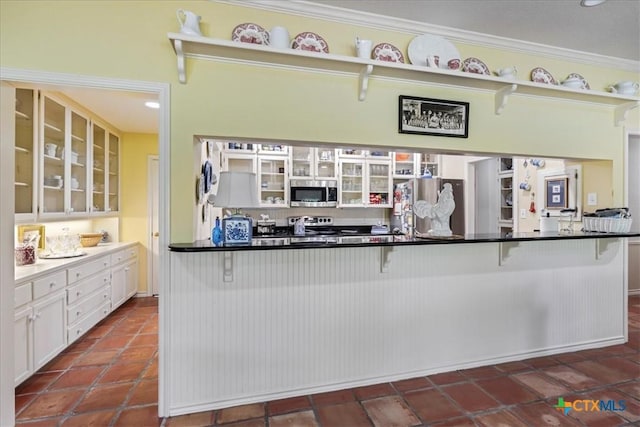 13650 Blackberry Rd, Salado, TX 76571 - kitchen with stainless steel appliances, a kitchen bar, glass insert cabinets, white cabinets, and crown molding
