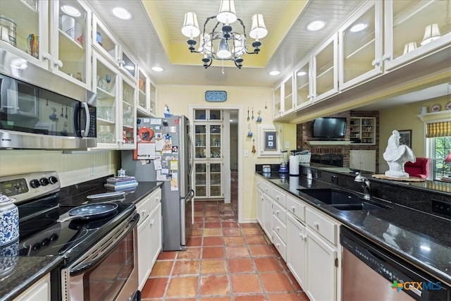 13650 Blackberry Rd, Salado, TX 76571 - kitchen with appliances with stainless steel finishes, a chandelier, a tray ceiling, white cabinetry, and glass insert cabinets