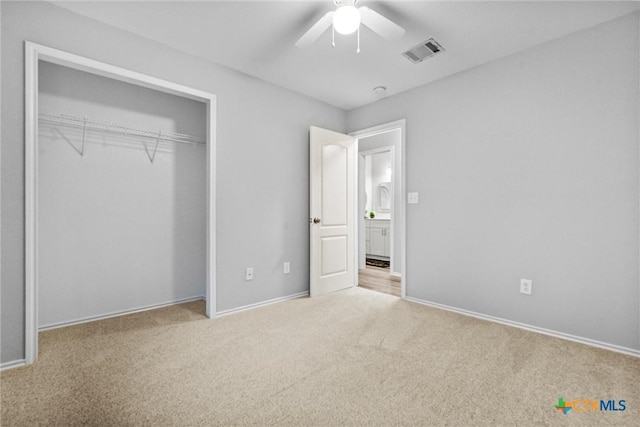 unfurnished bedroom with a closet, carpet, visible vents, ceiling fan, and baseboards