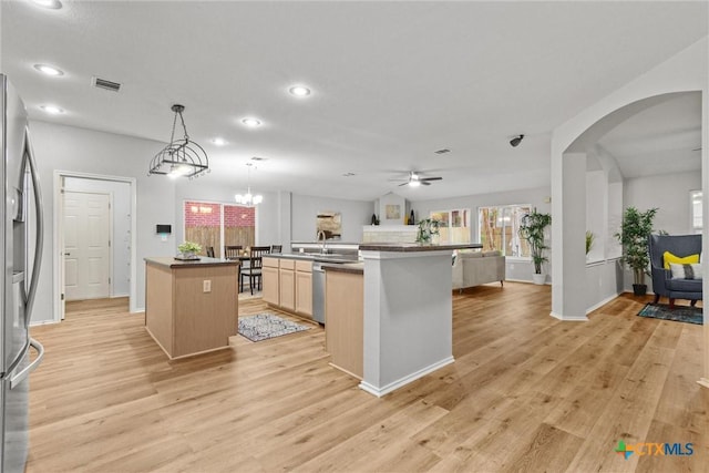 kitchen featuring light wood-style floors, stainless steel appliances, an island with sink, and visible vents