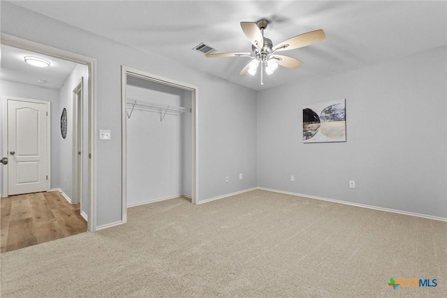 unfurnished bedroom featuring carpet flooring, a closet, visible vents, baseboards, and ceiling fan