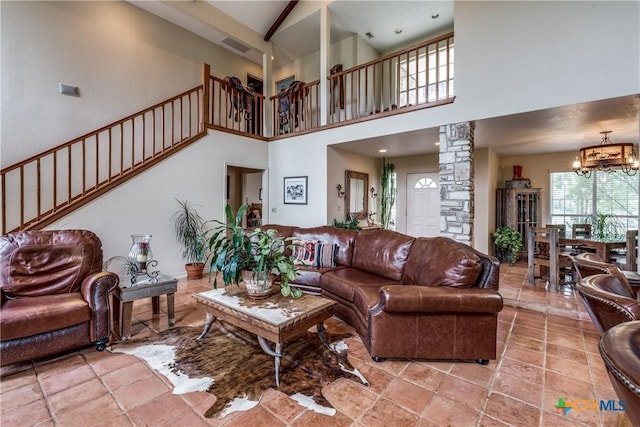 10767 Rosemar Ln, Adkins, TX 78101 - living area with a chandelier, a high ceiling, decorative columns, stairs, and light tile patterned floors