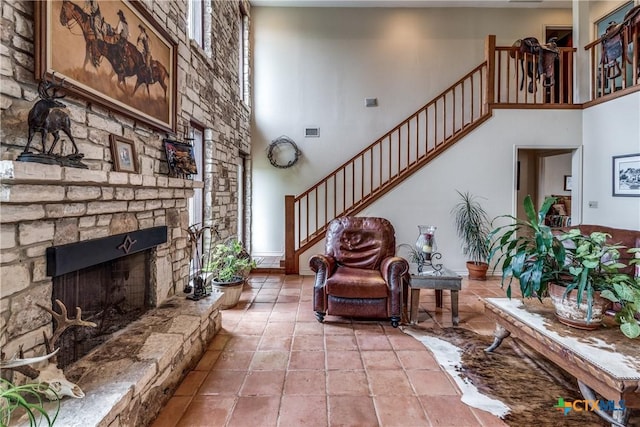 10767 Rosemar Ln, Adkins, TX 78101 - living room featuring a towering ceiling, stairs, and a stone fireplace