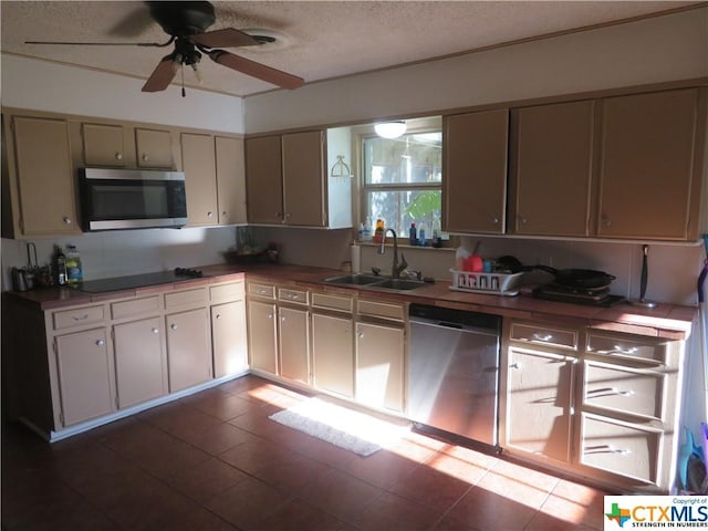 kitchen with ceiling fan, appliances with stainless steel finishes, sink, and a textured ceiling