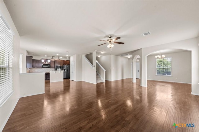 3303 Lorne Dr, Killeen, TX 76542 - unfurnished living room with arched walkways, a chandelier, ceiling fan, dark wood finished floors, and stairway