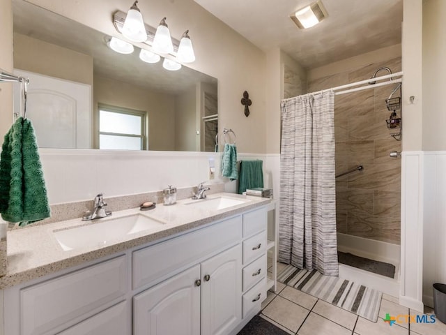 bathroom with tiled shower, tile patterned floors, and double vanity