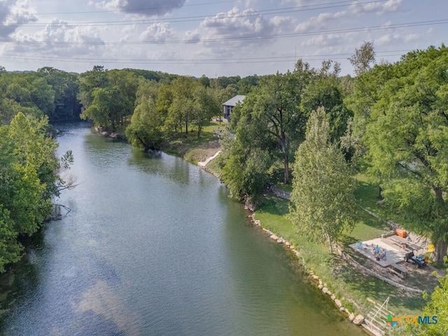view of property location with a large body of water and a heavily wooded area