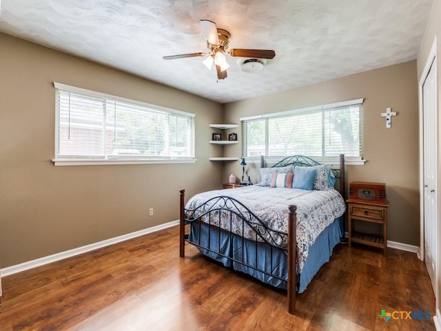 bedroom with baseboards, wood finished floors, ceiling fan, and a closet