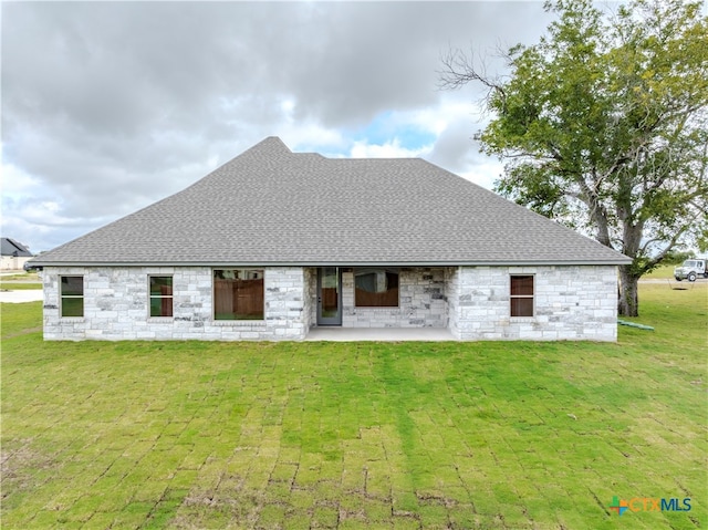 back of property with a lawn and a patio area