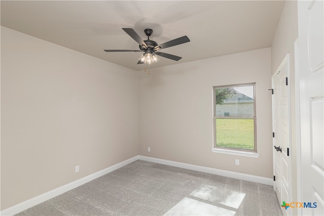 carpeted spare room with ceiling fan