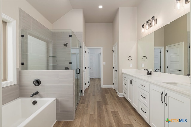 bathroom with hardwood / wood-style floors, vanity, high vaulted ceiling, and independent shower and bath