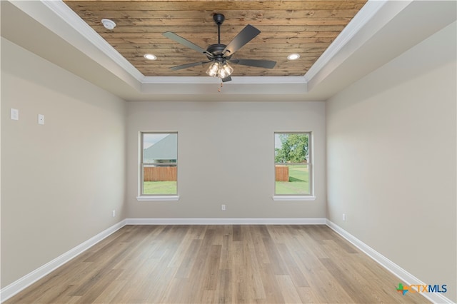 unfurnished room featuring wooden ceiling, ornamental molding, ceiling fan, a raised ceiling, and light wood-type flooring