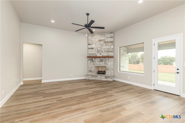 unfurnished living room with a fireplace, ceiling fan, and light wood-type flooring