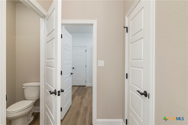 bathroom with toilet and hardwood / wood-style floors