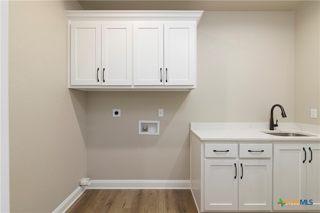 laundry area featuring electric dryer hookup, cabinets, hardwood / wood-style flooring, sink, and hookup for a washing machine