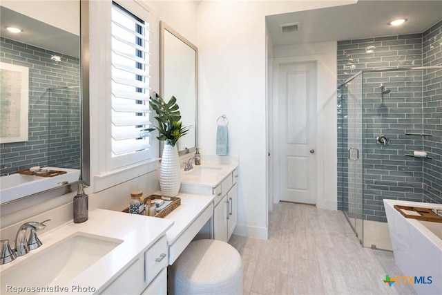 bathroom with walk in shower, vanity, hardwood / wood-style flooring, and a healthy amount of sunlight