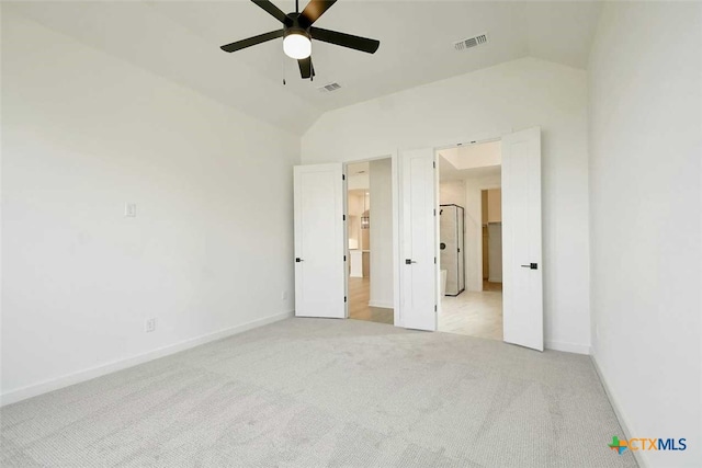 unfurnished bedroom with vaulted ceiling, light colored carpet, and ceiling fan