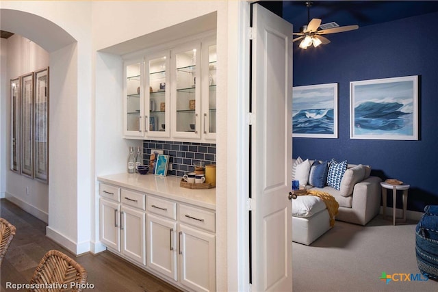 bar featuring white cabinets, ceiling fan, dark hardwood / wood-style floors, and decorative backsplash