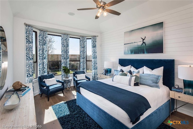 bedroom with wood-type flooring, ceiling fan, and wooden walls