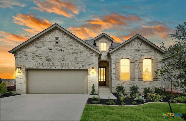 french country home featuring a garage and a yard