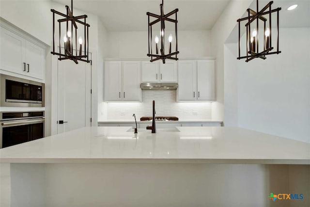 kitchen featuring pendant lighting, appliances with stainless steel finishes, and white cabinets