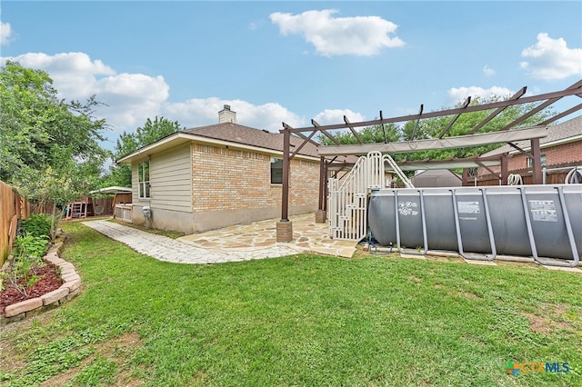 211 Gettysburg Loop, Elgin, TX 78621 - back of property featuring a patio area, brick siding, a fenced backyard, a chimney, and a lawn