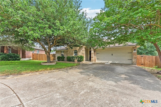 211 Gettysburg Loop, Elgin, TX 78621 - view of property hidden behind natural elements featuring driveway, brick siding, a garage, and fence
