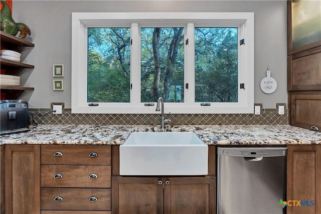 119 Stageline Dr, Kyle, TX 78640 - kitchen with stainless steel dishwasher, a sink, plenty of natural light, and light stone counters