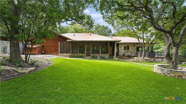 119 Stageline Dr, Kyle, TX 78640 - back of house featuring a sunroom, stone siding, a yard, metal roof, and a standing seam roof