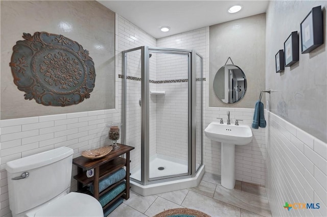 119 Stageline Dr, Kyle, TX 78640 - full bathroom with tile walls, tile patterned floors, a stall shower, toilet, and a wainscoted wall