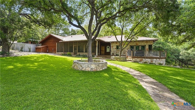 119 Stageline Dr, Kyle, TX 78640 - back of house with a sunroom, stone siding, a yard, metal roof, and a standing seam roof