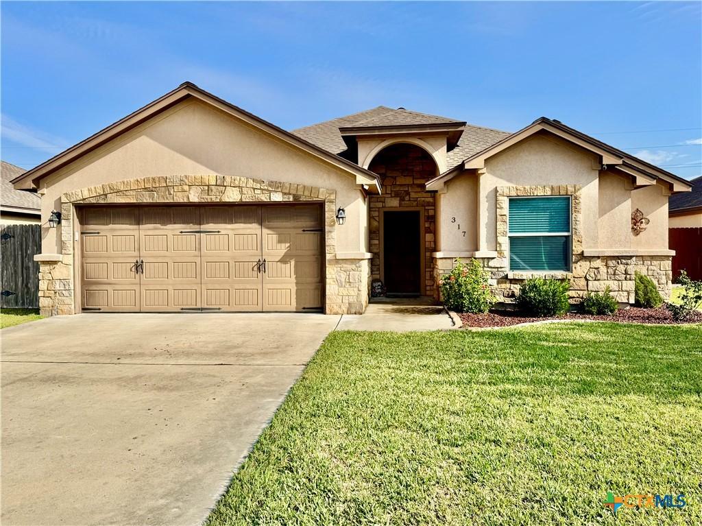 view of front facade with a garage and a front lawn