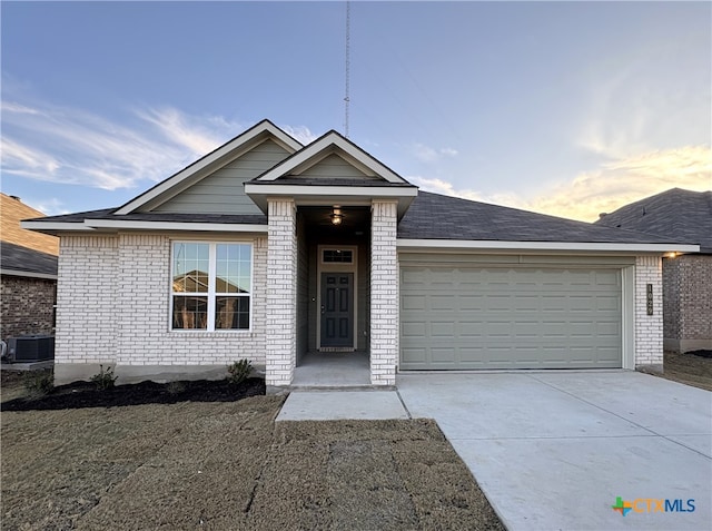 view of front of home featuring a garage and central AC unit