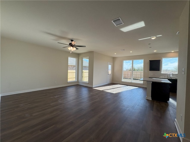 unfurnished living room with dark wood-type flooring and ceiling fan