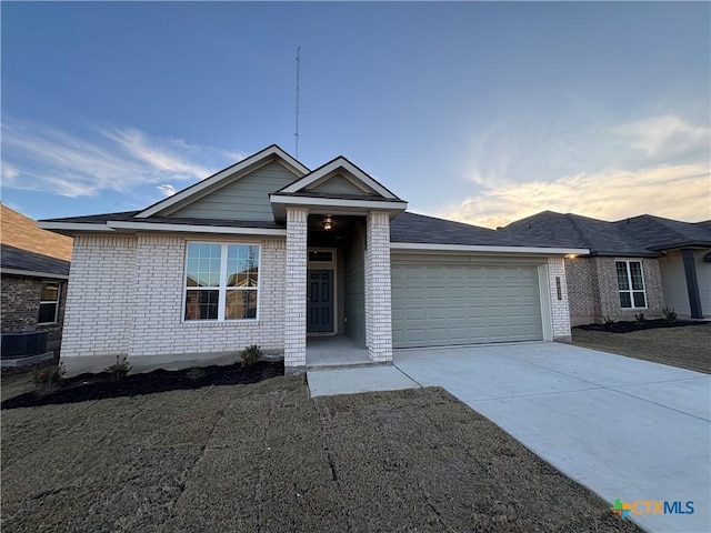 view of front of property with a garage and central air condition unit