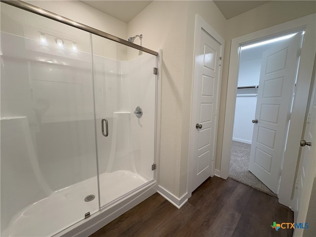 bathroom featuring wood-type flooring and a shower with door