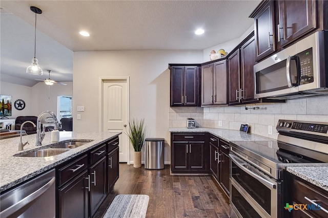 kitchen with a sink, ceiling fan, dark wood-type flooring, decorative backsplash, and stainless steel appliances